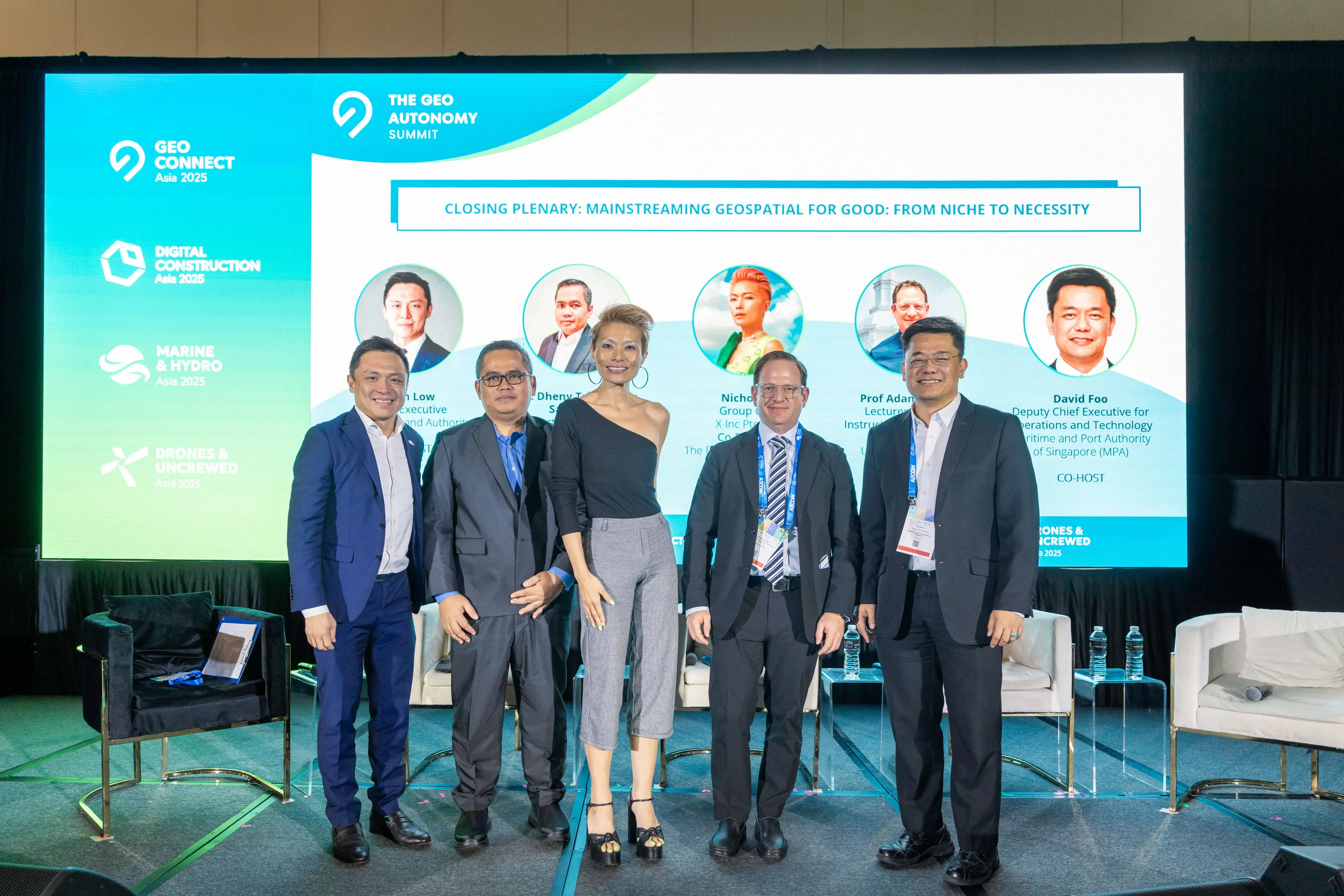 Five panelists pose on stage at the Geo Autonomy Summit closing plenary on mainstreaming geospatial technology.